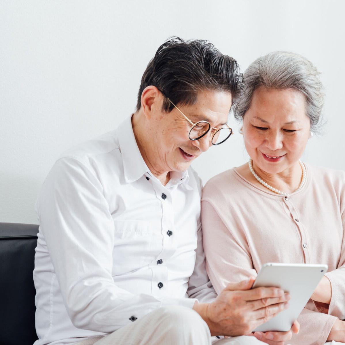 Senior Couple using tablet at home
